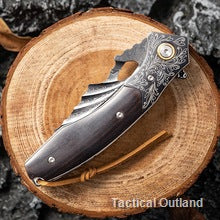VG10 Damascus folding knife displayed on a wood slice