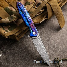Blue-handle Damascus folding knife on outdoor gear