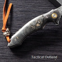 Close-up of a VG10 Damascus folding knife with textured dark handle