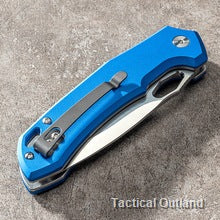 Closed blue VG10 folding knife on a concrete surface