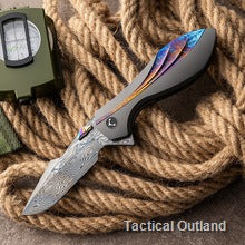 Open VG10 Damascus folding knife with patterned blade on outdoor gear