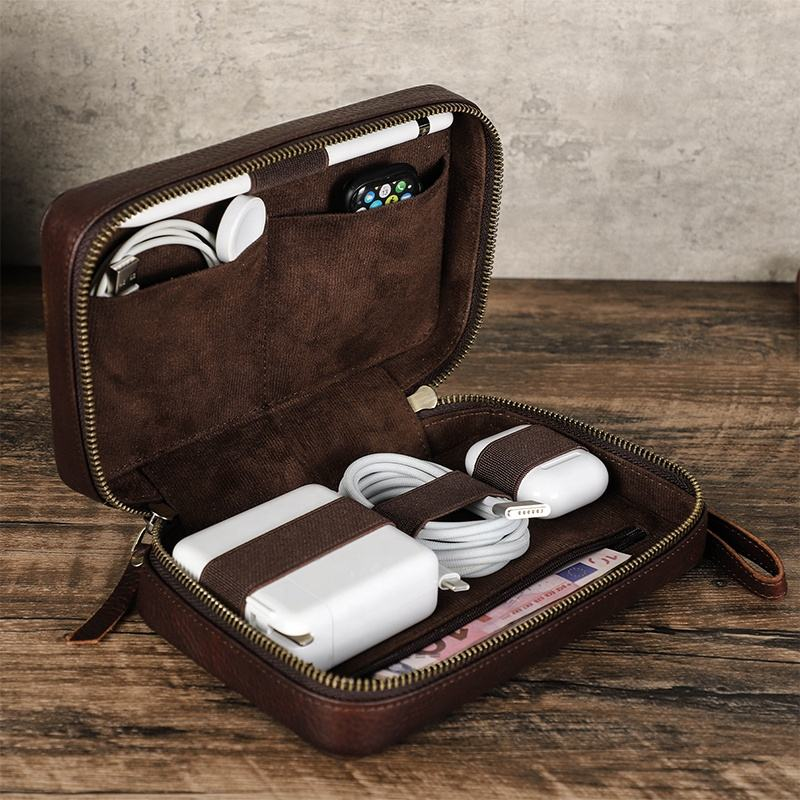 Open leather tech organizer holding chargers cables and earbuds