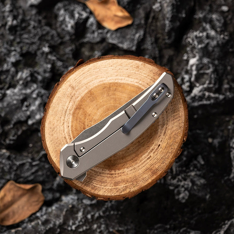 M390 folding knife closed on a wood-grain display