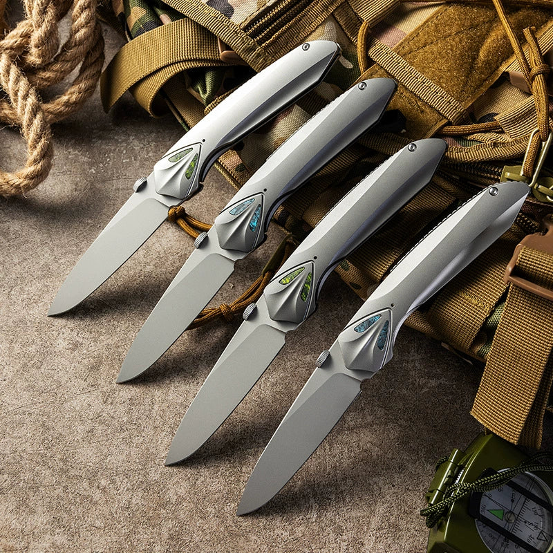 Unsharpened titanium-alloy folding knife displayed with outdoor gear