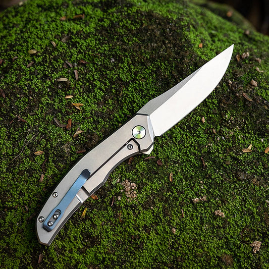 M390 outdoor folding utility knife on a mossy field background
