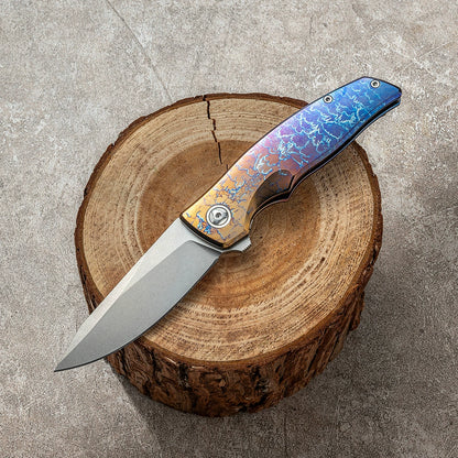 Damascus VG10 unsharpened folding knife on a wood display