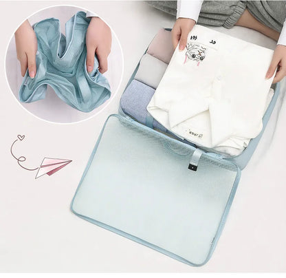 Light blue packing cube holding folded clothing in a suitcase