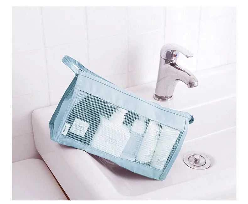 Light blue mesh toiletry organizer holding travel-size bottles beside a sink