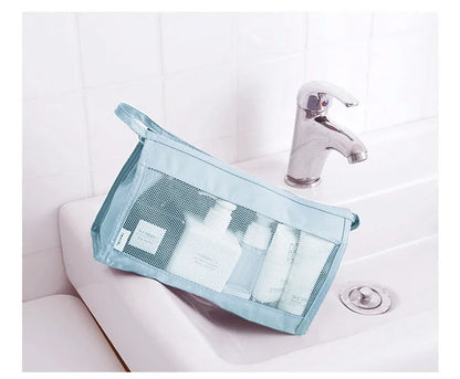 Light blue mesh toiletry organizer holding travel-size bottles beside a sink